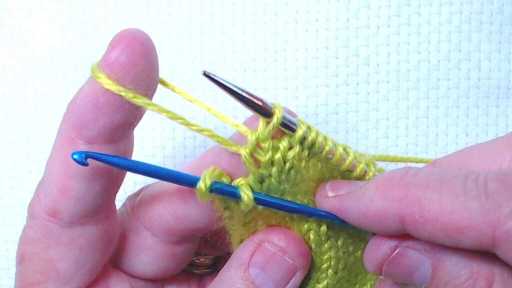 2 stitches on crochet hood with index finger holding the dropped rows