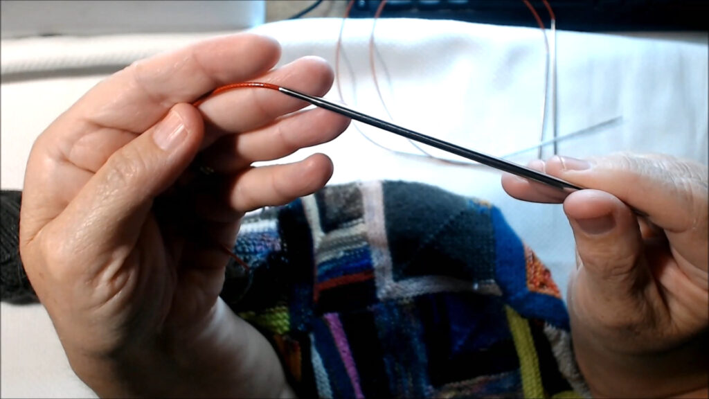 hands hold ChiaoGoo Red Lace Circular Needles