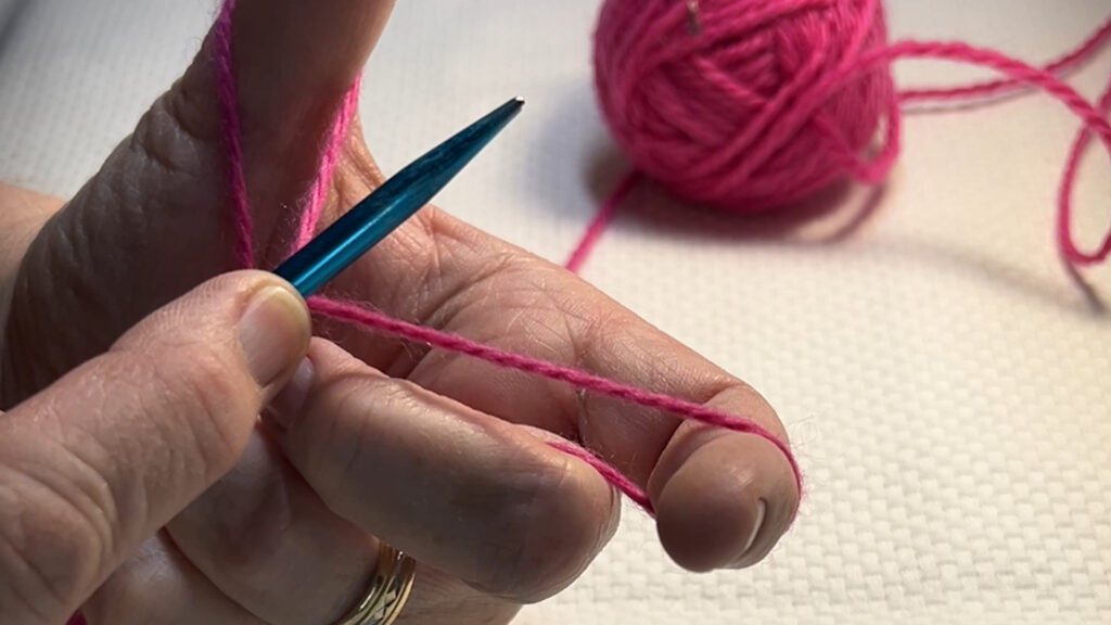 hands and yarn and needles casting on