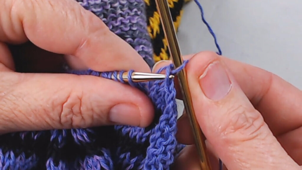 needle inserted into stitch below