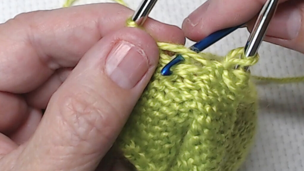 using crochet hook to grab bar to bring through stitch